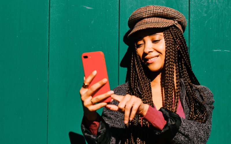 woman with braids using a smartphone
